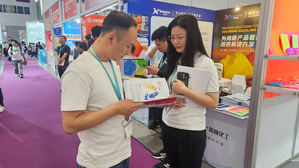 觀眾在精顏化工展位體驗產(chǎn)品手冊